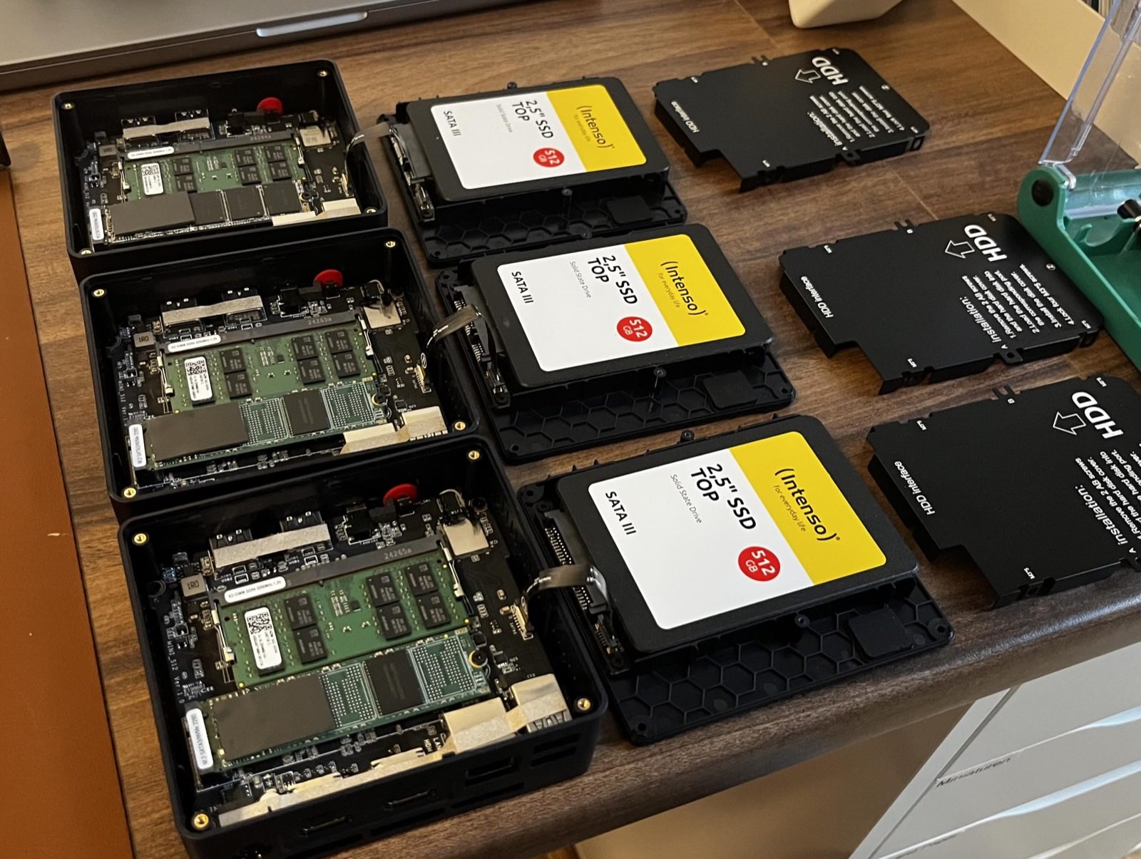 Three mini PCs with their cases open during assembly