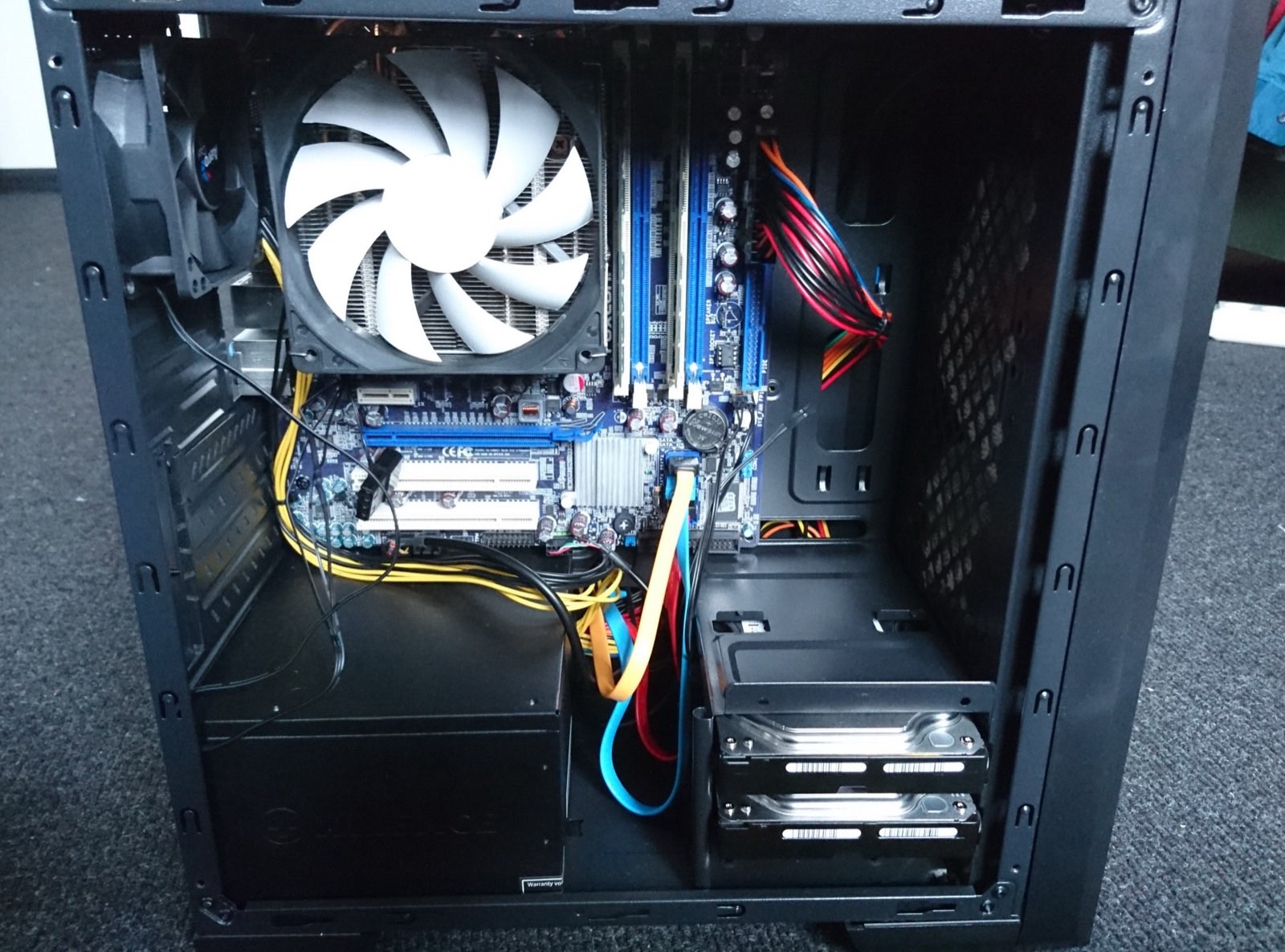 The first NAS build, an Intel Q8200 machine with a towel in front of it
